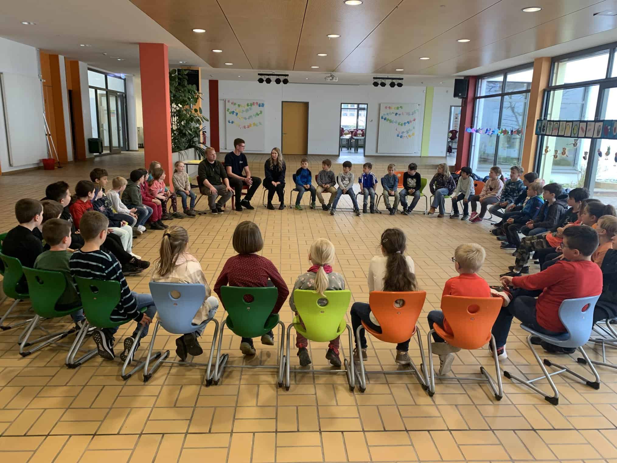 Die Schüler der OGS des BNG und der RSM stehen vor einem Polizeiwagen.
