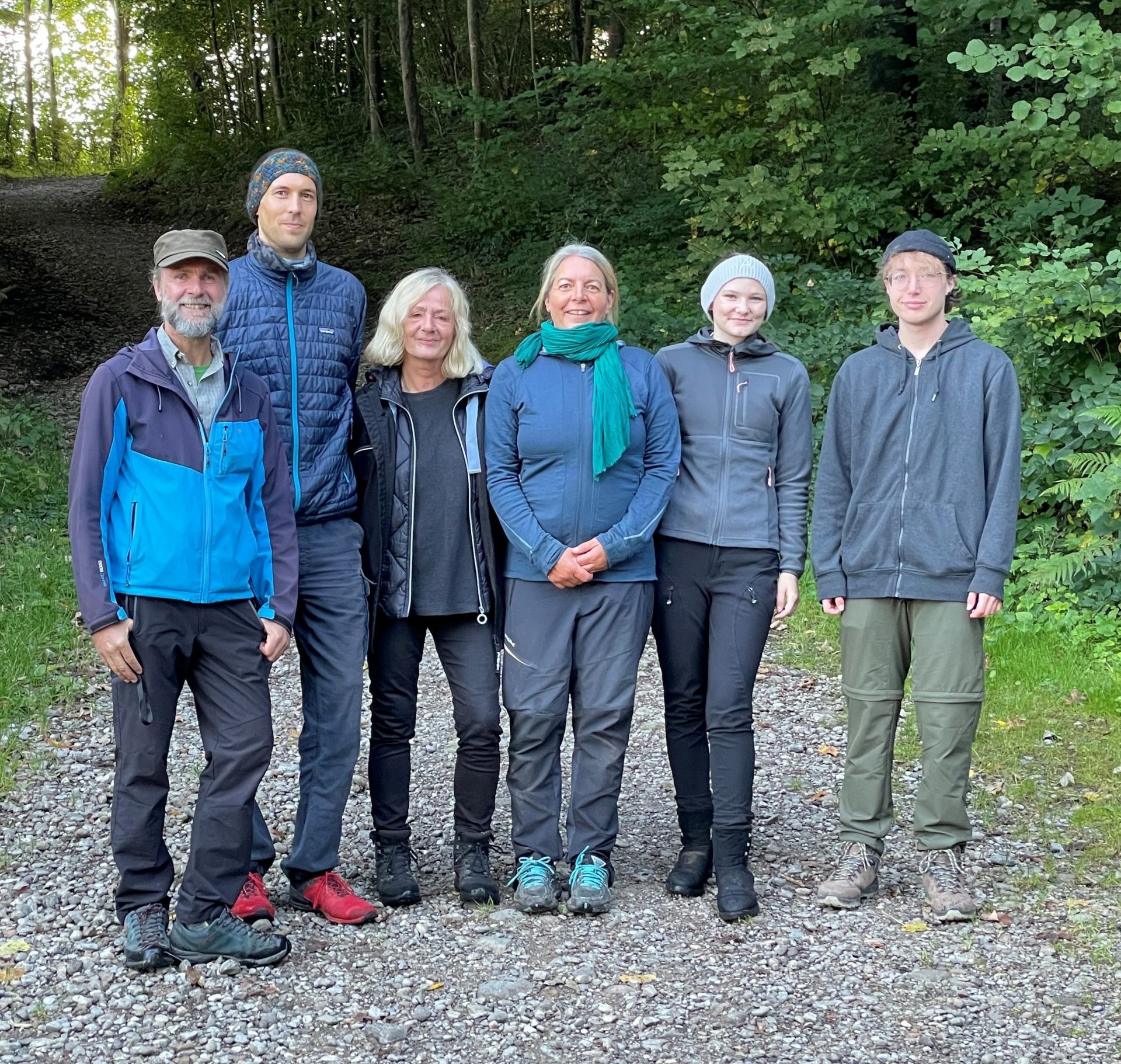 Das Team des Waldkindergarten Sulzberg steht in einer Reihe auf einem Waldweg.