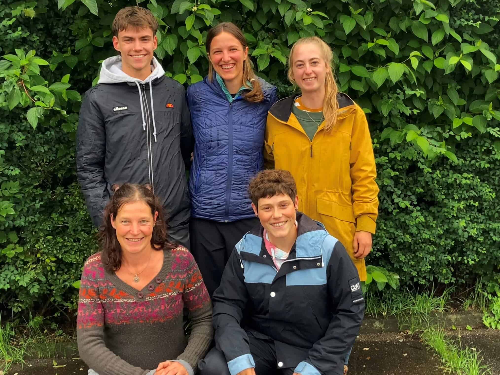 Teamfoto Das Team des Waldkindergarten Maria Thann steht vor einer Hecke.
