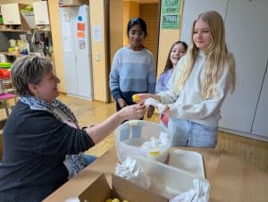 Kinder tauschen ihre gefundenen gelben Ostereier gegen ein kleines Geschenk.