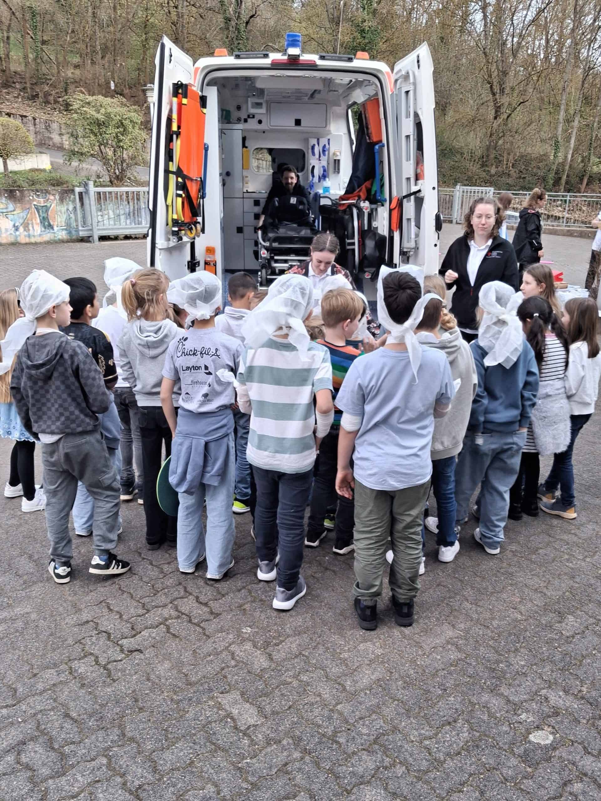 Die Schüler der OGS des BNG und der RSM stehen vor einem Polizeiwagen.