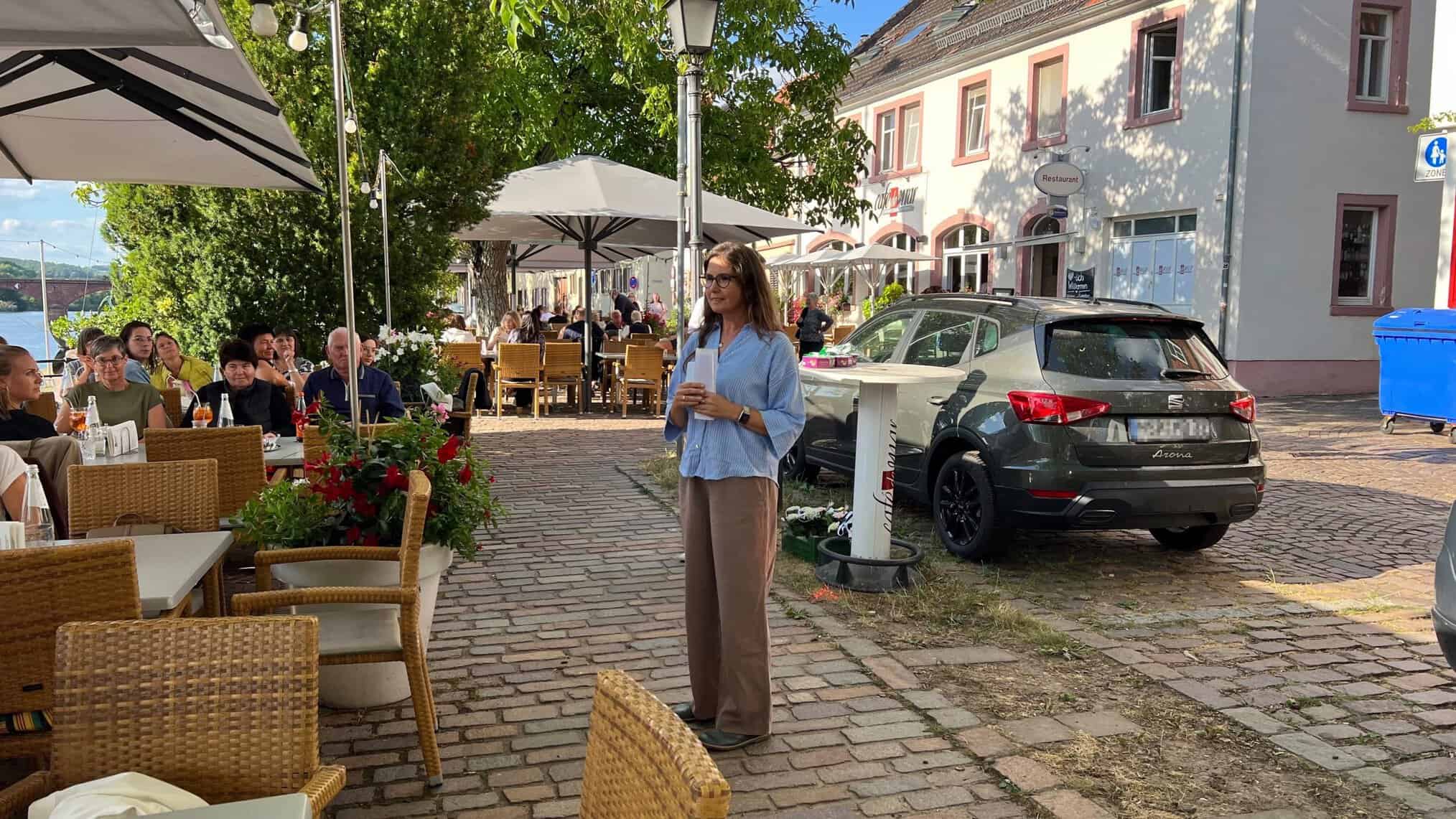 Kerstin begrüßt die Mitarbeiter:innen zum Schuljahresabschluss 26 im Café de Mar.
