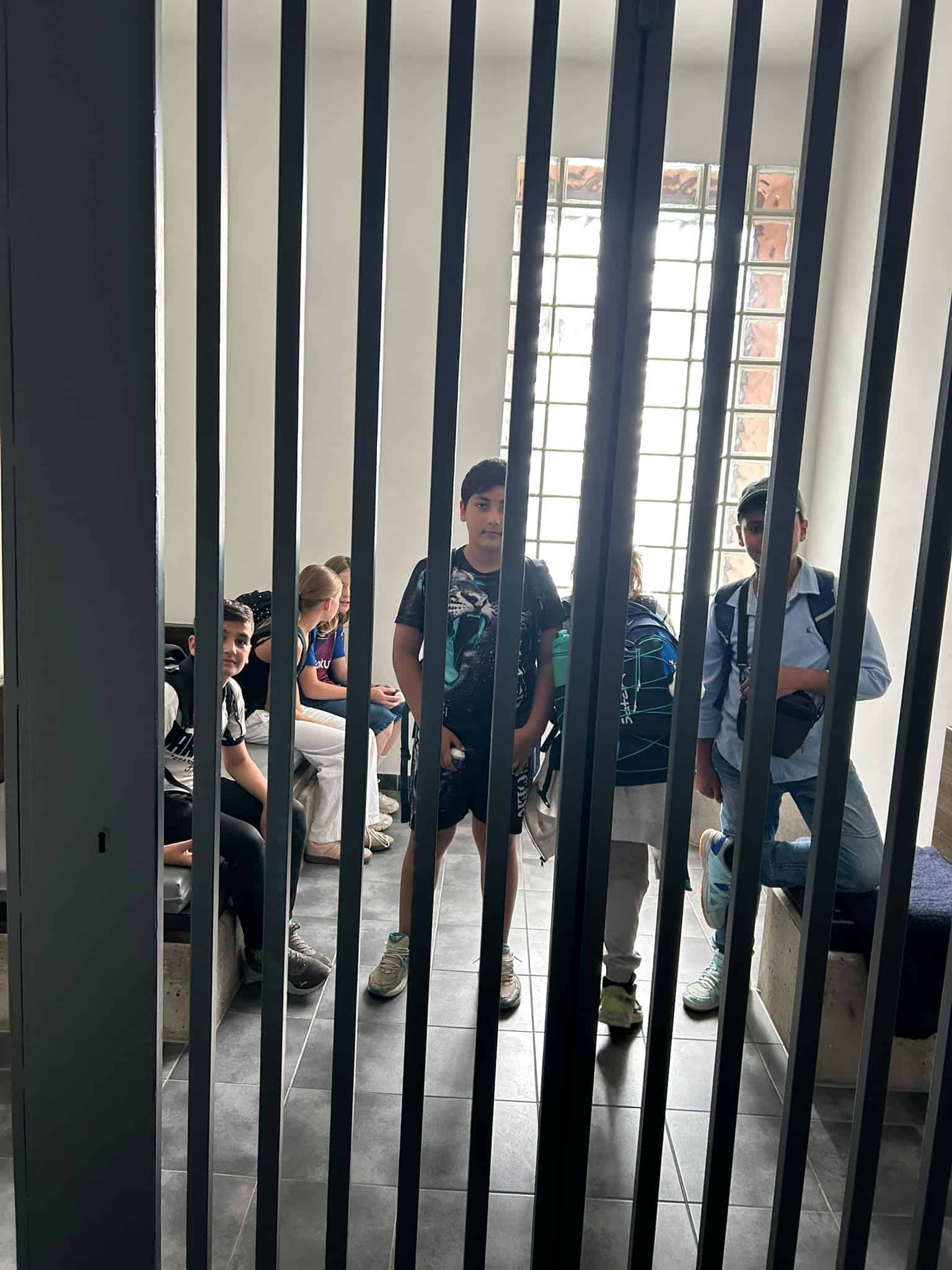 Die Schüler befinden sich in einer Zelle in der Polizeistation.